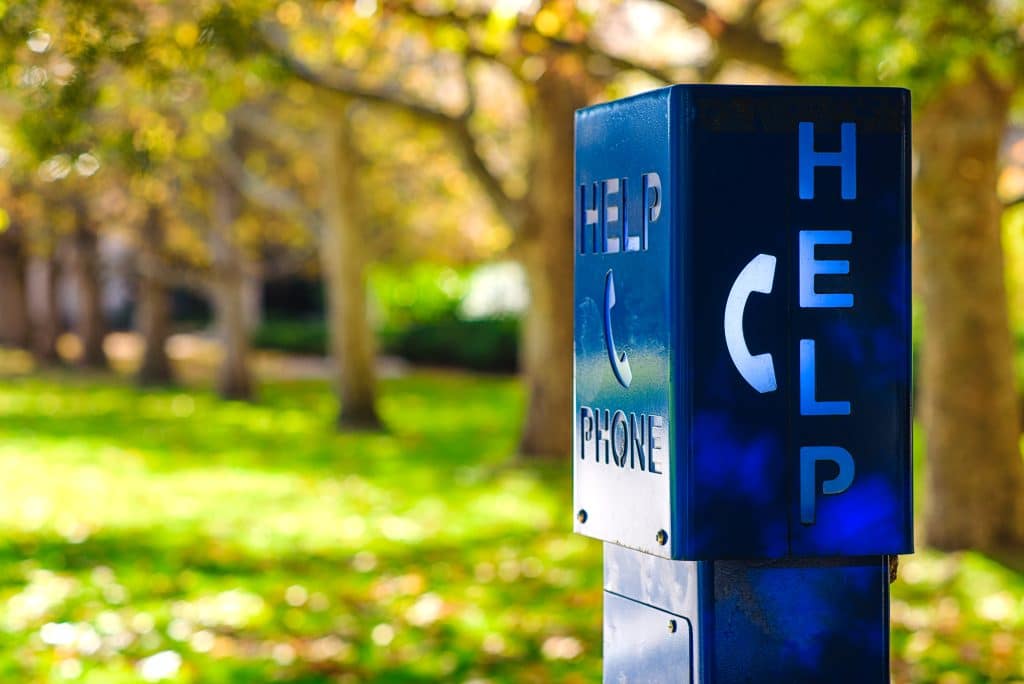 A blue emergency phone box labeled "HELP" at a university campus in Melbourne, Australia.