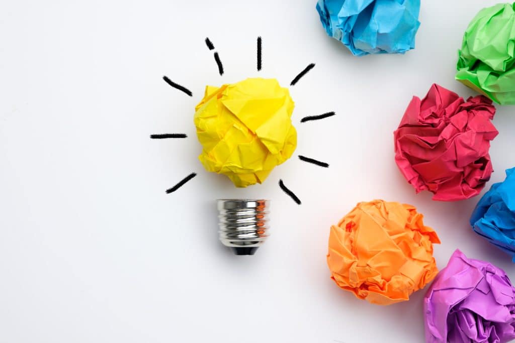 Great idea concept with crumpled colorful paper and light bulb on white background
